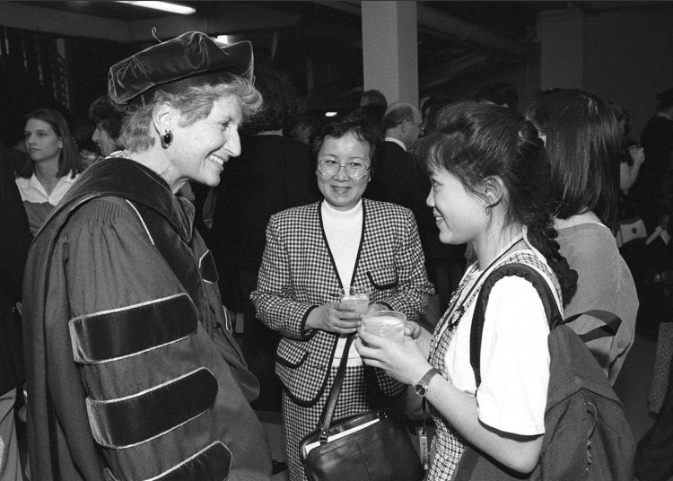 Photo of Mary Gates talking with student and parent.