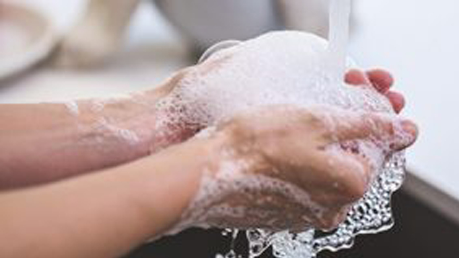 Photo of hands being washed.