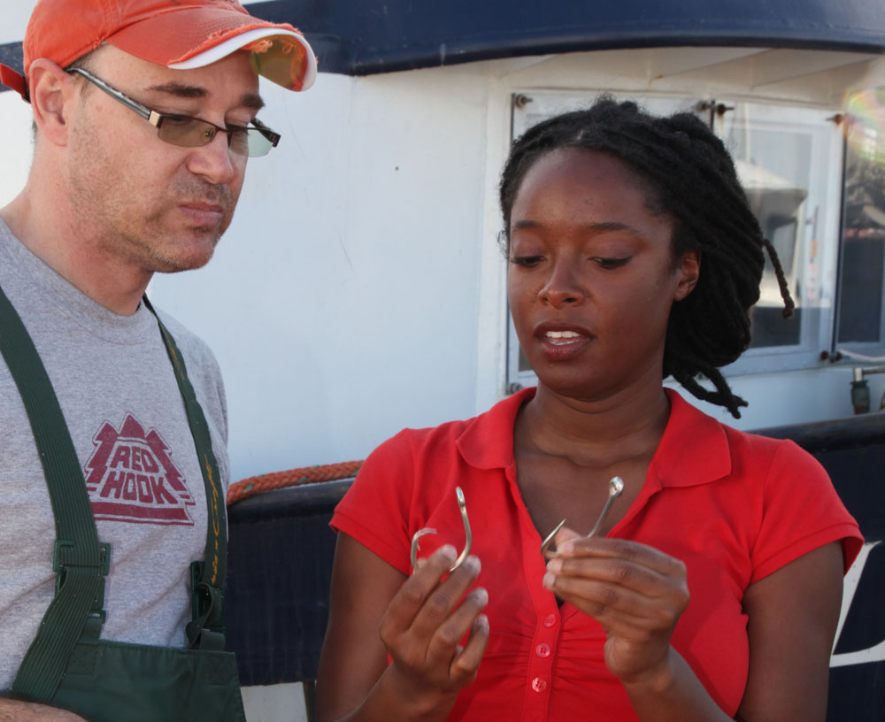 Kiki Jenkins compares a circle hook to a J-shaped hook. Both fish and turtles are less likely to swallow circle hooks. Photo credit: Debra Spencer