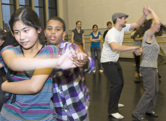 Amazing Grace students Fherna Caoili and Isaac Abraham dance in the foreground, while UW students Casey Duranleau and Erika Najarro practice their moves behind them. | Photo by Kathy Sauber