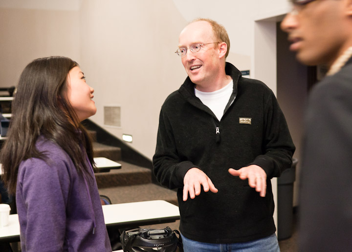Matt Sparke, director of the global health minor, talks to undergraduates after class in the introductory course on global health. Sparke is a professor of geography and international studies.
