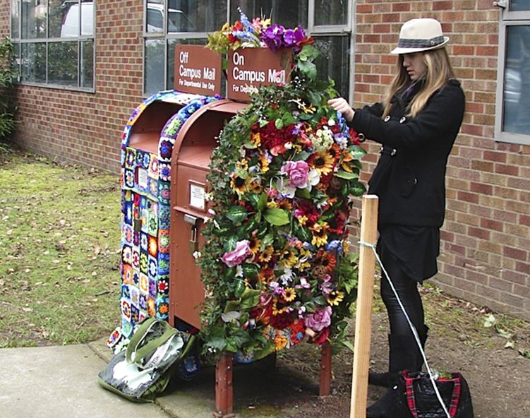 Madelyn Hagen works on the flower mailbox; next to it is the granny afghan mailbox. | Photo by Marco Solis-Bethancourt