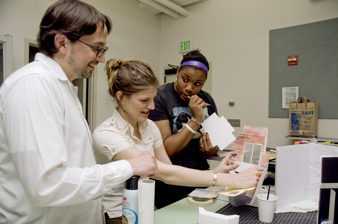 Students Jackie Blodgett, left and Liz Lay show their design to Drama Professor Robert Morgan.