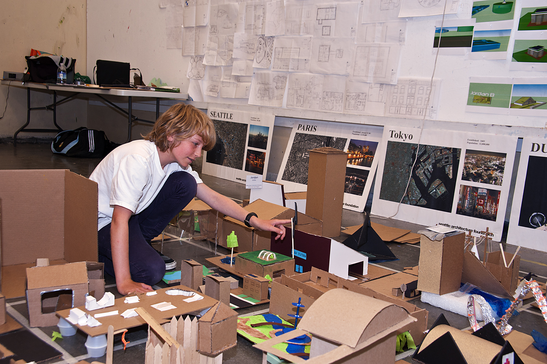 Henry Watts, 13, adjusts his addition to a cardboard city built as part of the Summer Youth Programs class called Community Architecture: Solving Social and Environmental Issues Through Design. His working partner was Jordan Broihie, also 13.