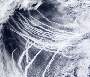 A satellite image shows white streaks stretching across the ocean. The streaks are ship trails, clouds the form around pollution emitted from ships into the air.