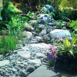 Plants, stone walkway and face of stone in garden