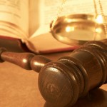 A gavel, law book and scales of justice.