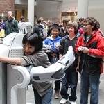 A student gets a hug from a robot.