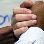 Black and white hands clasped.