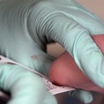 Blood is drawn from the heel of a newborn for screening.