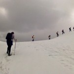 Students in line walking across top of snow-covered ridge