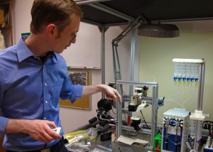 Man stands at lab table with X-ray diffraction apparatus