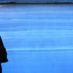 A researcher stands in a snow pit next to an Antarctic ice core.