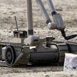 A United States Army explosive ordnance disposal robot pulls the wire of a suspected improvised explosive device in Iraq.