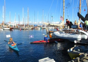 Two kayakers visit boaters, handout packages with adapters