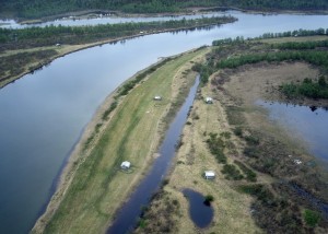 Dozen hayhuts on land surrounded by water