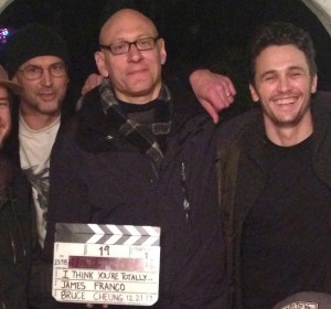 The cast and crew of "I Think You're Totally Wrong: A Quarrel," a film directed by James Franco of a forthcoming book by David Shields and Caleb Powell. Shields is at center, holding the clapboard. Franco is to his right, Powell at his left.