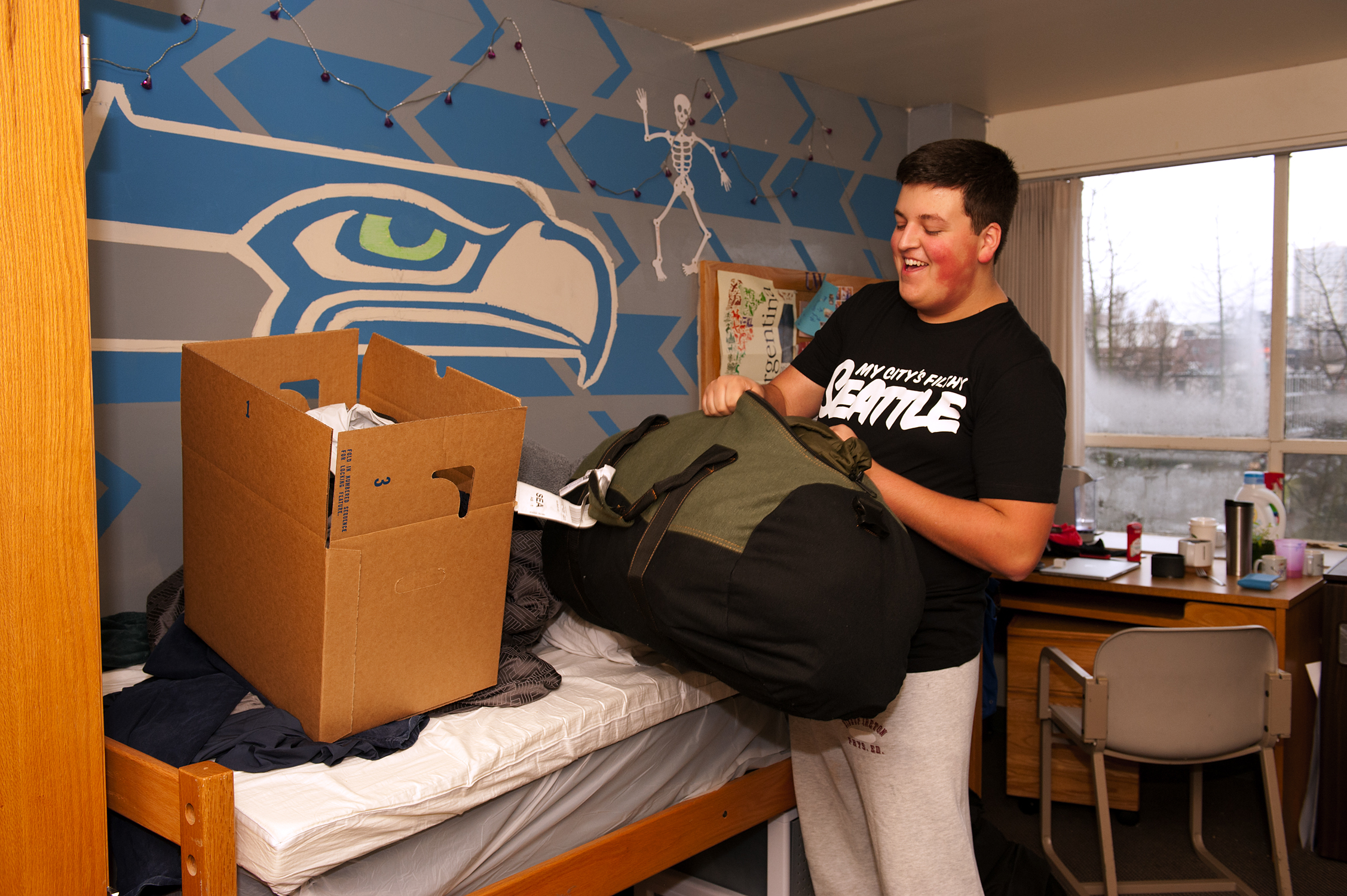 Student Ben Ferrara packs up his room in preparation for moving to the new Lander Hall. Since the building is soon to be closed, he and roommate Evan McAuley were allowed to paint a Seahawks logo on their wall.