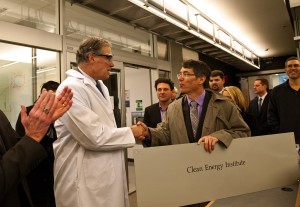 Gov. Jay Inslee (center) shakes hands with Dan Schwartz, director of the new Clean Energy Institute, with UW President Michael Young (left).