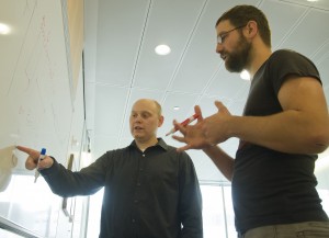 Population geneticists Joshua Akey (left) and Benjamin Vernot (right) discuss models of human evolution.