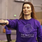 A woman lifts a kettlebell.