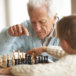 elderly man teaches chess