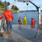 people on boat deploying instrument