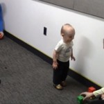During the "choice trial" of a research experiment, a baby chooses one experimenter to play with.