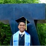 Man stands in cap and gown