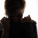 A woman sits in a dim room