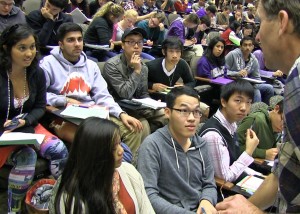 Man talks with two rows of students in class auditorium