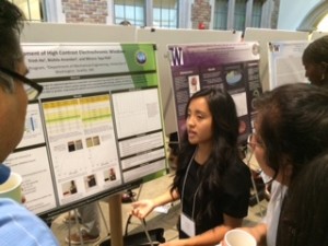 Trinh Ha, an incoming freshman who will study engineering, talks with visitors at the UW Summer Undergraduate Research Poster Session Wednesday, Aug. 20, 2014.