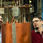 UW physicists Leslie Rosenberg (left) and Gray Rybka examine the Axion Dark Matter Experiment detector package.