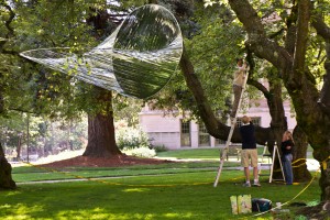 Artist Alyson Piskorowski, right, looks on as colleagues help her install her untitled work in the Quad outside Savery Hall. Piskorowski, who earned an MFA from the UW in sculpture and public art, is one of several UW alumni showing art during the Mad Campus art exhibition.