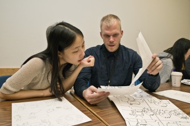 Undergraduate students Xiangyi (Anne) Zheng, left, and Daniel Aldridge give feedback on each other's comics at a recent class.