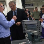 Gov. Jay Inslee learns about riveting from Boeing engineer Riley Hanson Smith, left, and Sai Krovvidi, a UW doctoral student in mechanical engineering, at the opening of the Boeing Advanced Research Center on campus.
