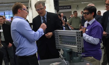 Gov. Jay Inslee learns about riveting from Boeing engineer Riley Hanson Smith, left, and Sai Krovvidi, a UW doctoral student in mechanical engineering, at the opening of the Boeing Advanced Research Center on campus.
