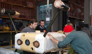 From left to right: UW researchers Ben Rush, Nick Michel-Hart, James Joslin and Paul Gibbs prepare to test the monitoring device underwater in a tank on campus.