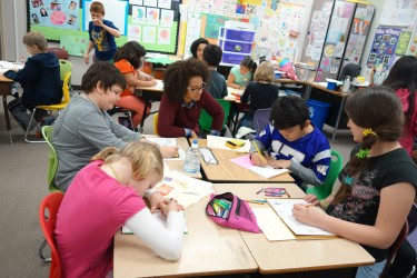 Alexandra Lynn Zepeda, middle, works with students at Forks Elementary on a literacy project.