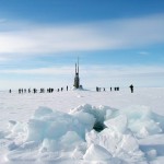submarine poking through ice and people disembarking