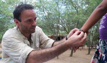 UW biologist Horacio de la Iglesia puts an activity logger onto a participant's wrist.