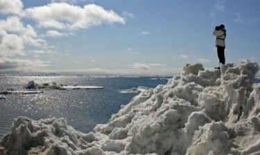 A National Marine Mammal Laboratory scientist searches for seals from a tall ice floe in the Bering Sea.