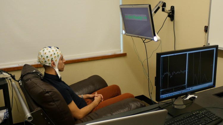 University of Washington graduate student Jose Ceballos wears an electroencephalography (EEG) cap that records brain activity and sends a response to a second participant over the Internet.