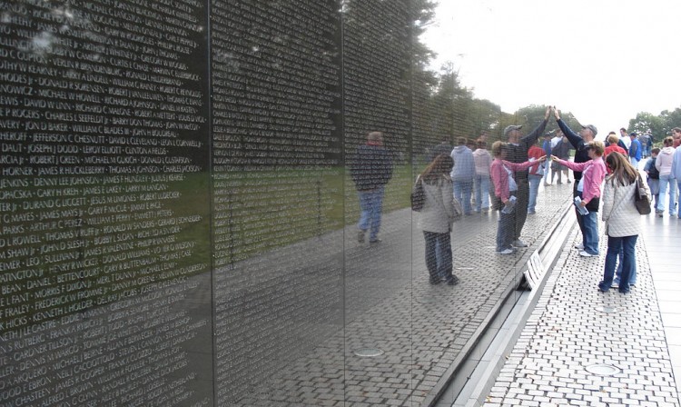 Visitors touch names and leave gifts at the Vietnam War Memorial in Washington, D.C., in 2006.