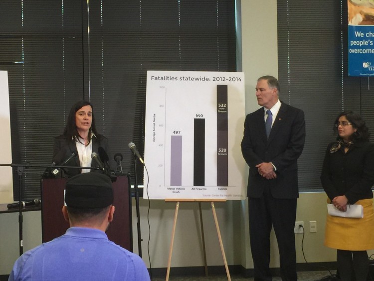 Jennifer Stuber, co-founder of Forefront: Innovations in Suicide Prevention, speaks while Gov. Jay Inslee and Monica Vavilala, director of the Harborview Injury Prevention and Research Center, look on.