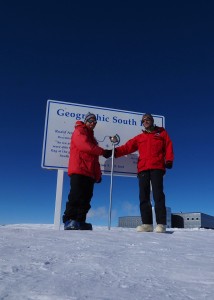 people in red coats in front of sign