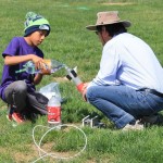 child and adult with bottle rocket
