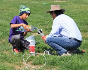 child and adult with bottle rocket
