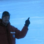person in red coat pointing at ice