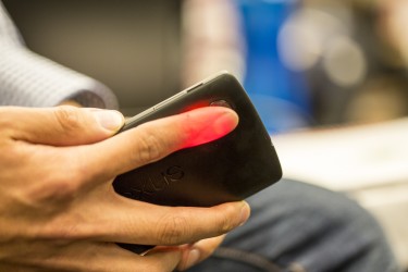 Photo of HemaApp illuminating a patient's finger